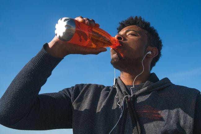 Man drinking a sports drink.