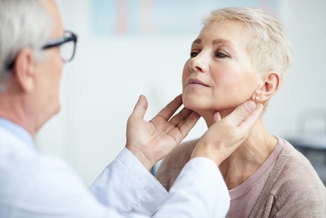 Doctor examining patients thyroid