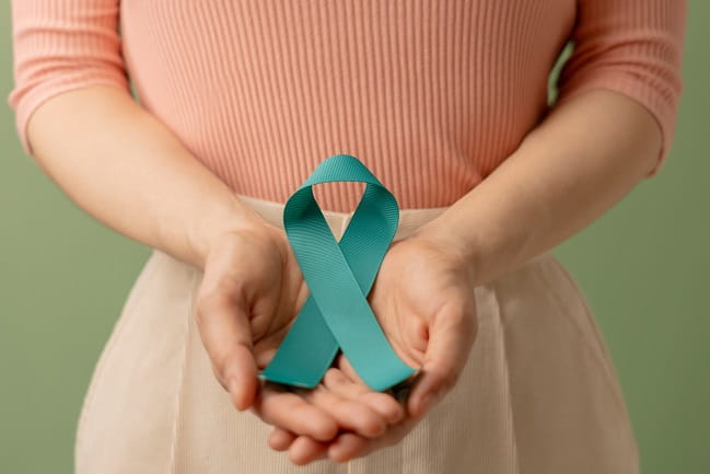 stock image of person holding a green ribbon in front of them with both hands.