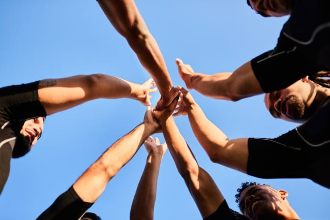 Athletic team in a circle putting hands in together