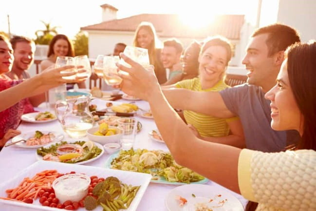 A group of smiling people toasting their drinks.