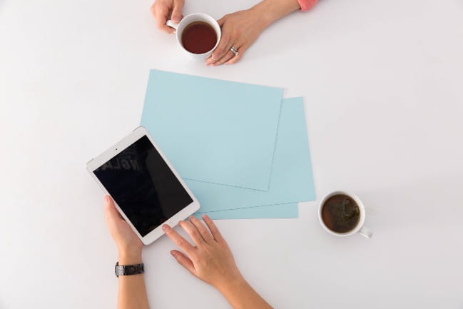 One person showing another something on a tablet.