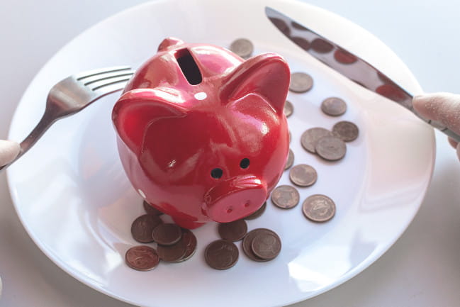A piggy bank sits on a dinner plate.