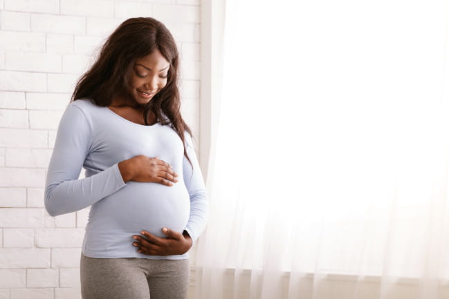 Pregnant woman holding her belly.