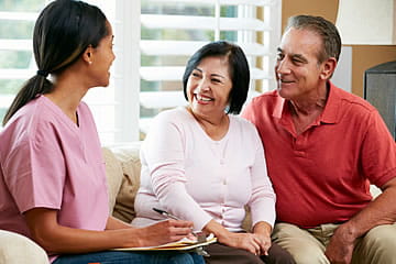 Image of an in-home nurse talking to a couple