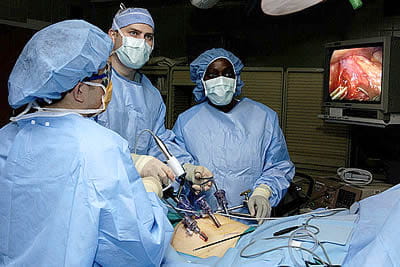 Surgeon, with nurses, performing an abdominal laparoscipic procedure.