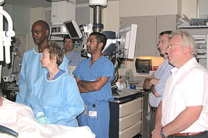 Two international short-term visitors (right) observing Dr. Brenda Hoffman perform a G.I. procedure.