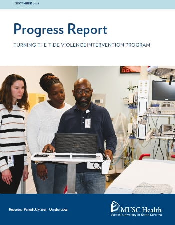Cover of the December 2023 Progress Report for Turning the Tide Violence Intervention Program showing three bedside care team members looking at a computer screen on a cart next to a bed. Reporting period: July 2021 to October 2023.
