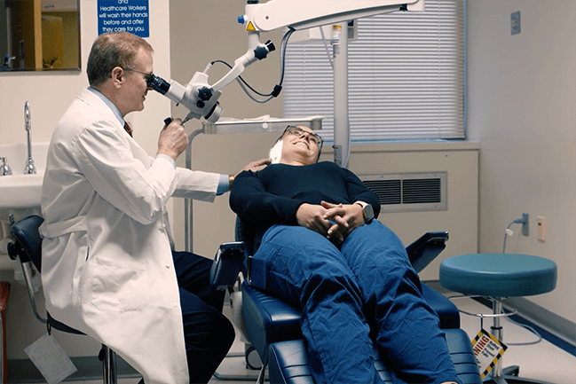 Caregiver examining patient with ENT device