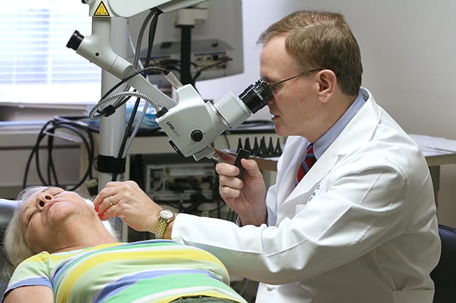 Paul R. Lambert, M.D. examining a patient
