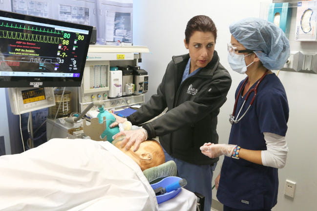 Two people training on a simulated patient.