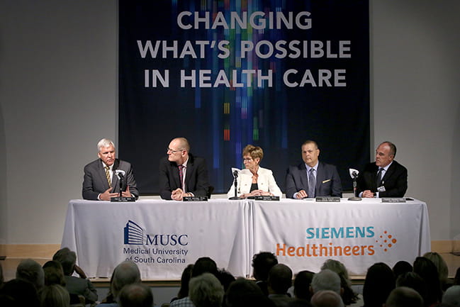 David Cole, MD, FACS, president of MUSC, is seated with Michael Saladin, PhD, & Patrick Cawley, MD, MUSC Health CEO, University Vice President of Health Affairs, as well as Siemens officials as they announce their partnership at a press conference.