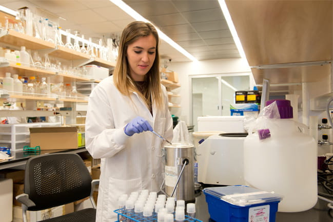 Researcher in white coat pictured in laboratory at MUSC