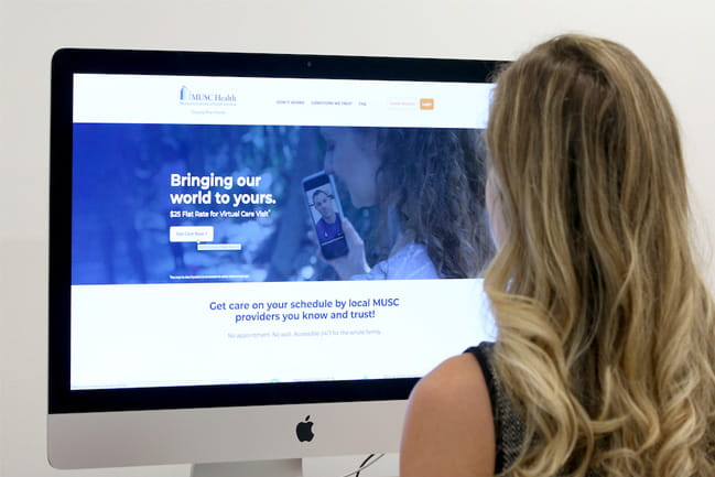 Young woman in front of MUSC Health Virtual Urgent Care screen