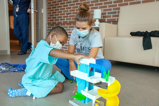 A child plays with a nurse at MUSC on the floor of the hospital. 
