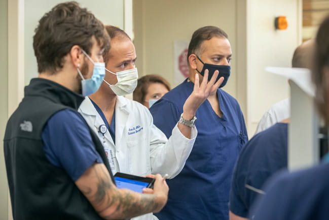 Dr. Arman Kilic, second from left, speaks during rounds in the cardiovascular intensive care unit at MUSC Health. 