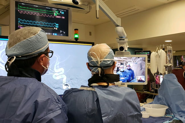 doctors collaborating in surgery with a screen