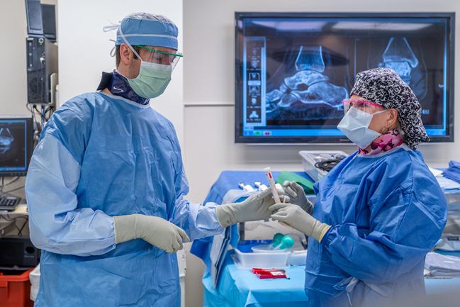 Surgeons exchanging a blood sample in an operating room