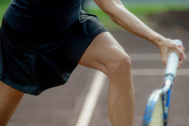 Closeup of female tennis player’s knee during match play