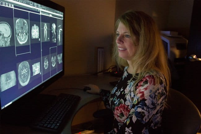 Woman examining brain scans ona computer screen
