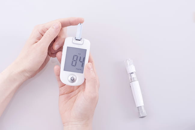 a woman takes her blood glucose levels
