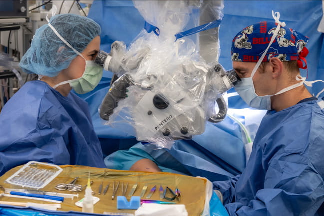 surgeons look into the robot to perform surgery