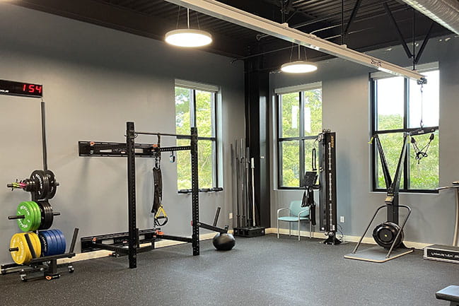 Open, airy gym with weights and other fitness equipment
