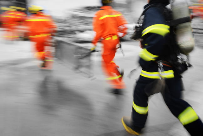 Firefighters in their gear walking and running 