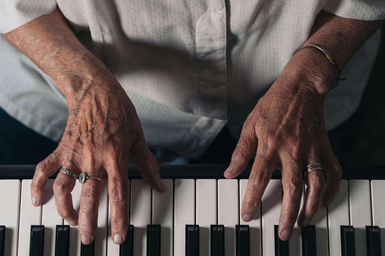 Hands of a senior woman playing piano
