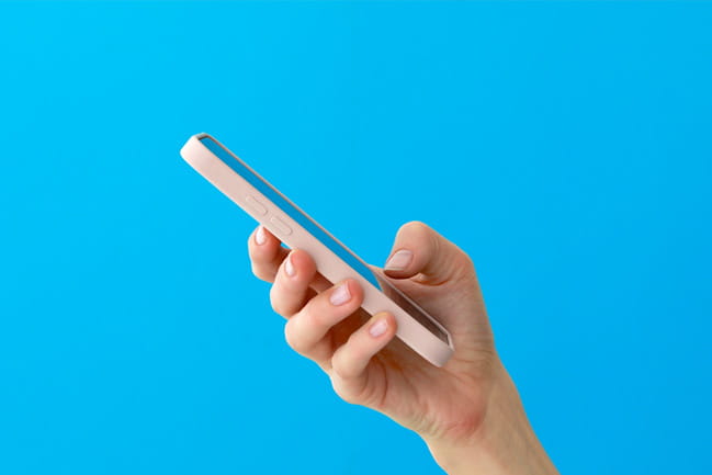 a person holding a cell phone in their hand over a blue background