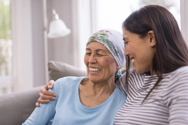 A laughing woman is emotionally supported by her relative as she goes through hospice at home care. 