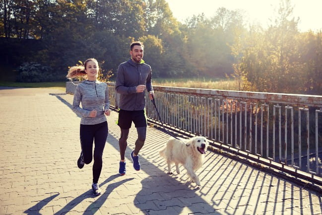 Couple jogging with dog