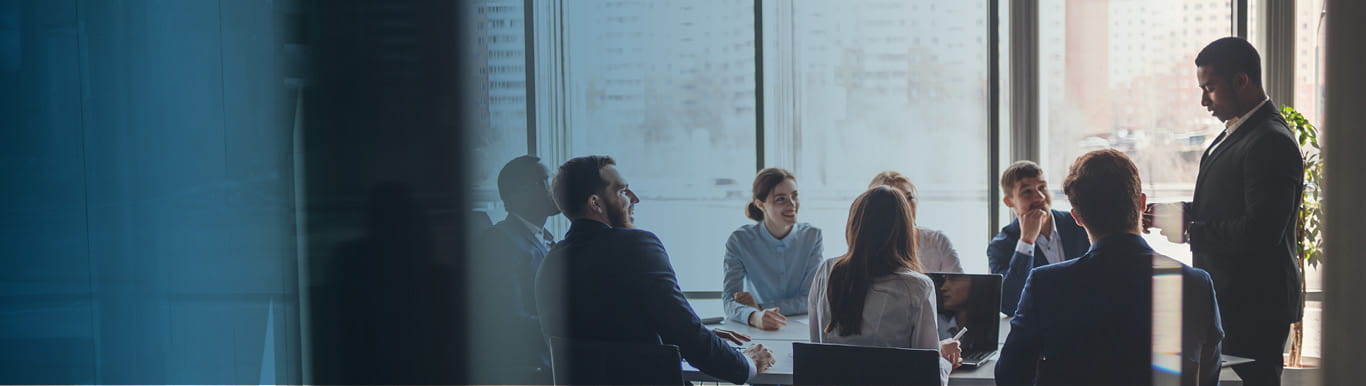 Man in suit giving presentation to other professionals