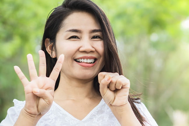 Smiling woman holding up four fingers