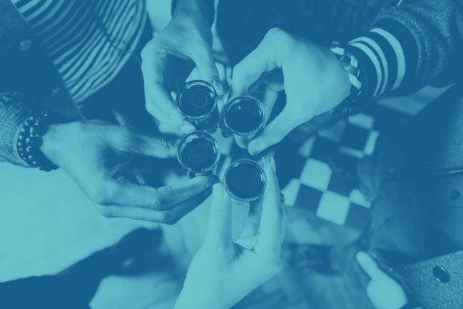 A group of people toasting shot glasses