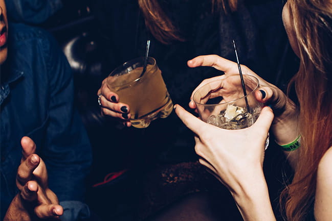 Photo of hands of 2 people holding drinks