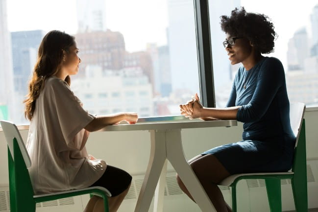 Two people at a table having a conversation.