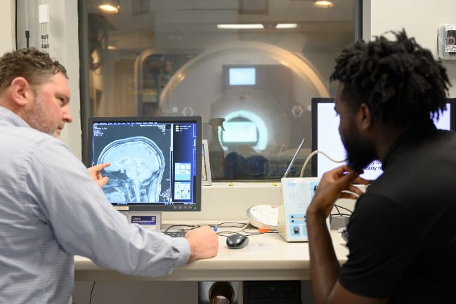 Two researchers looking at a brain scan.