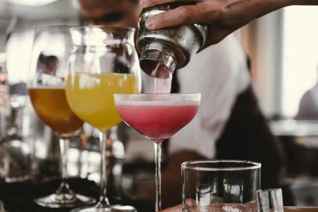 A bartender pours an alcoholic drink at a bar.