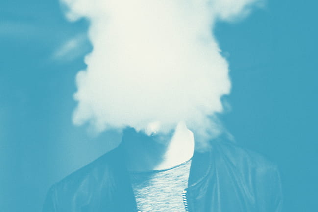 Image of a face obscured by a cloud of smoke