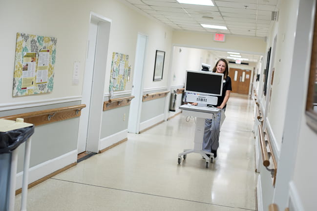 Photo of nurse transporting telehealth cart