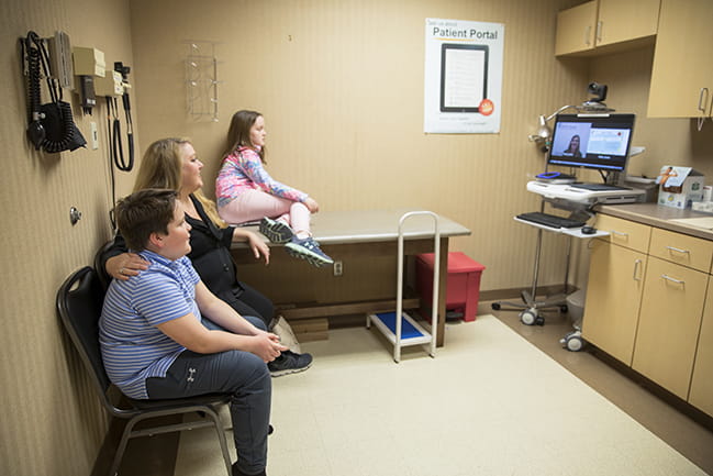 patient and family looking at provider on telemedicine cart screen