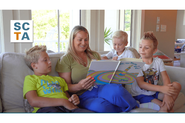 A mother reads a book to her children.