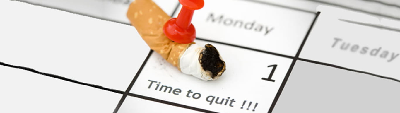 Calendar with a burnt cigarette pinned to a day that says Time to Quit.