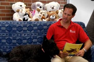 Chip reading a book with MUSC pet therapy dog, Arista.