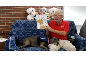 Robert reading with MUSC pet therapy dog, Sydney.