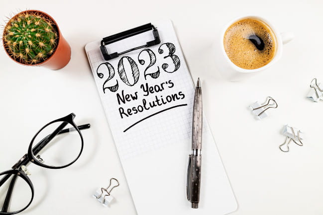 A pad of paper that says "2023 New Year's Resolutions"