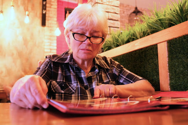 A person reads a menu at a restaurant.