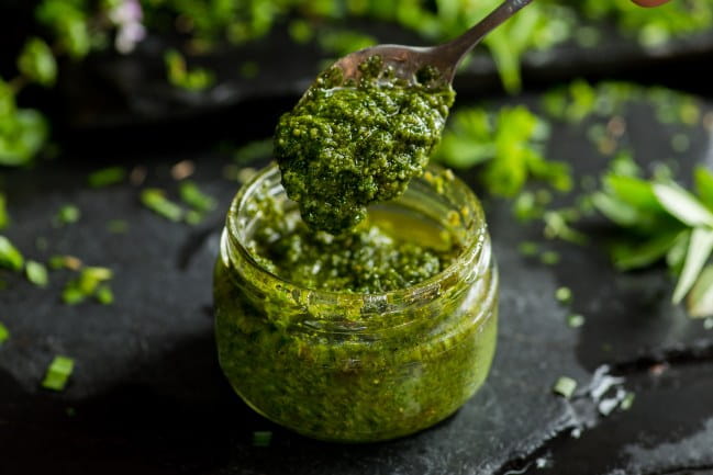  jar of pesto sauce with a spoon