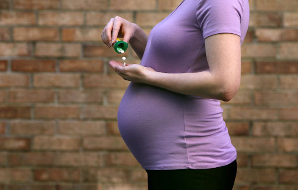 Pregnancy women with pill bottle in hand